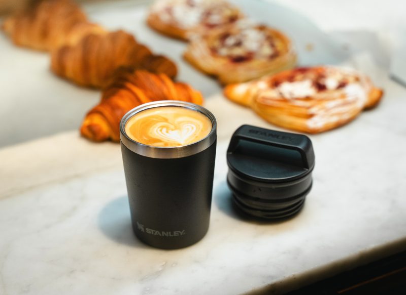 Black Stanley short stack mug in foreground with pastries in background
