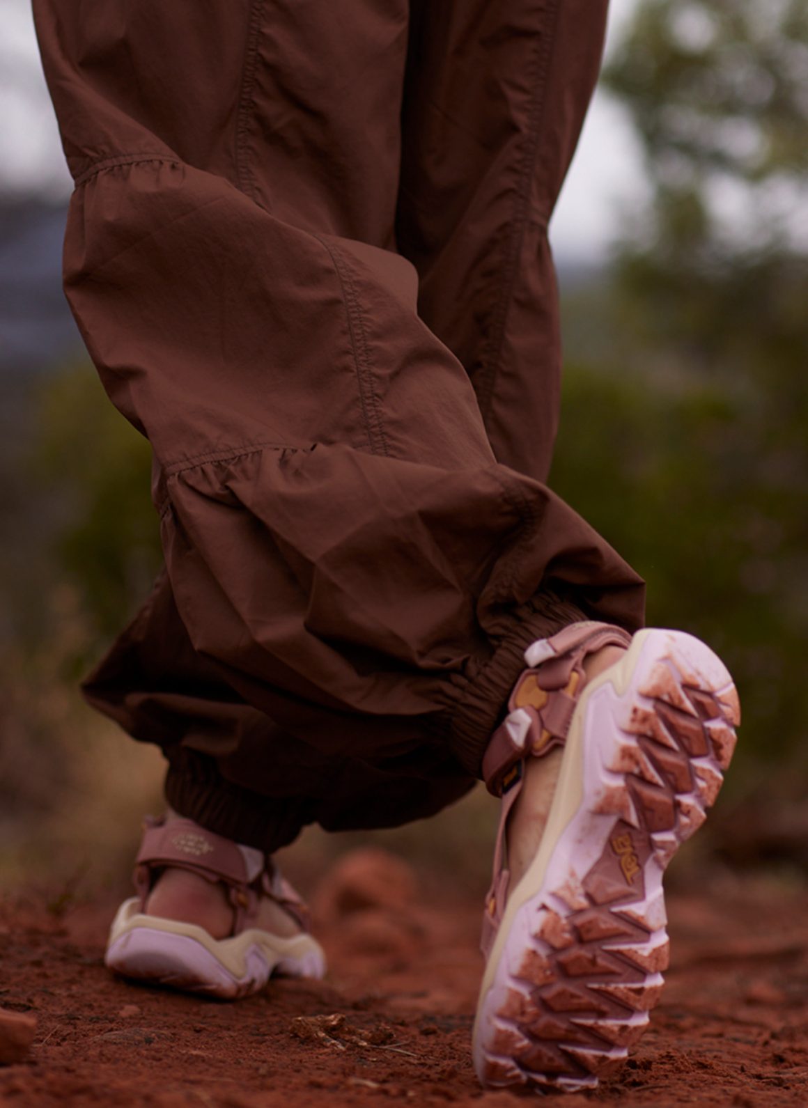 woman walking away from camera, wearing teva x free people movement collaboration sandals