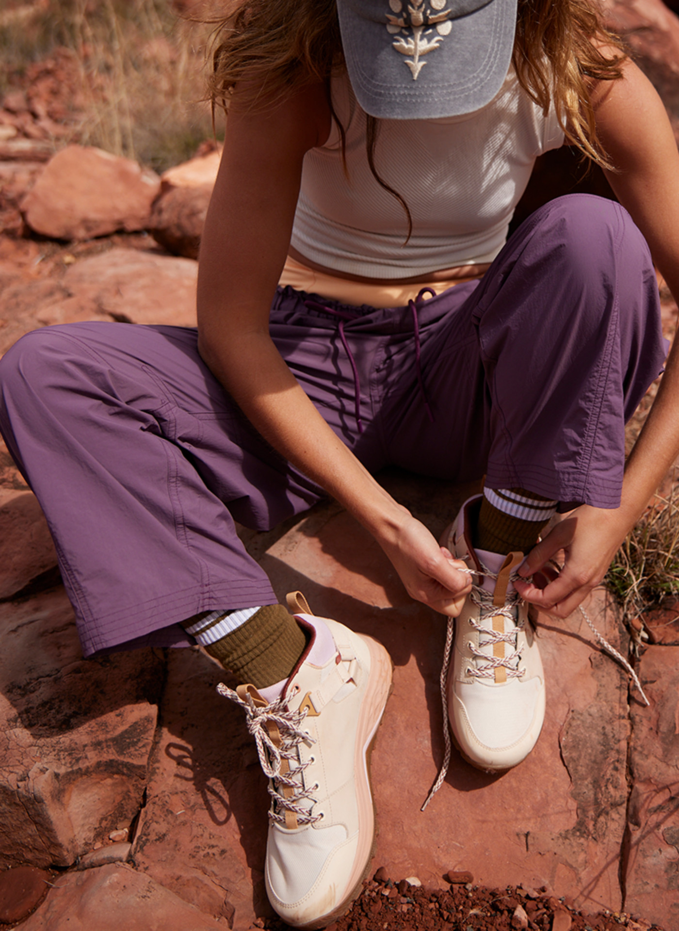 woman tying shoe laces wearing teva x free people movement trainers