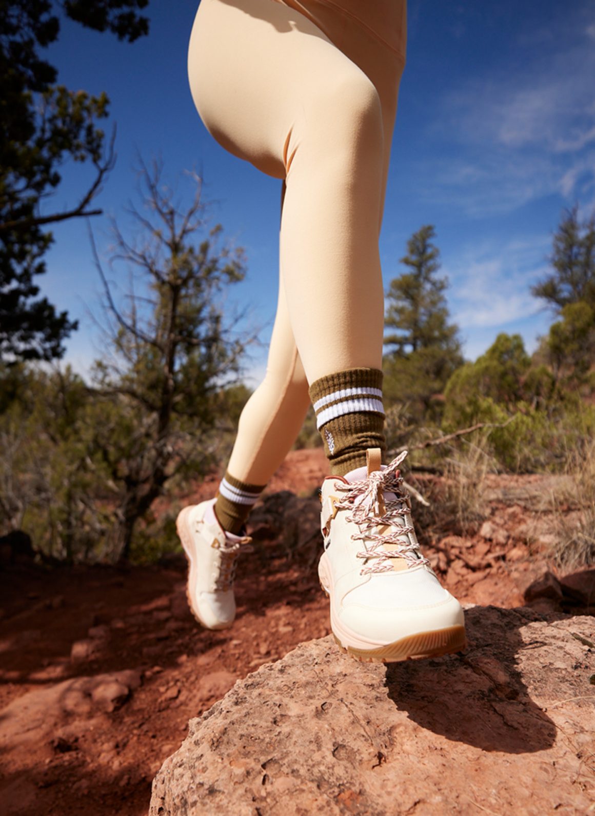 image of woman's legs leaping over rock. she is wearing teva x free people movement collaboration trainers