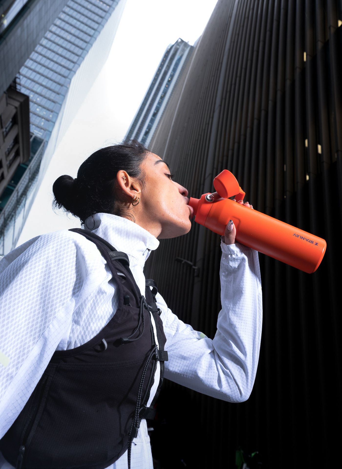 Creative case study for Stanley Europe. Image shows Savannah Sachdev drinking from a Stanley bottle in front of skyscrapers