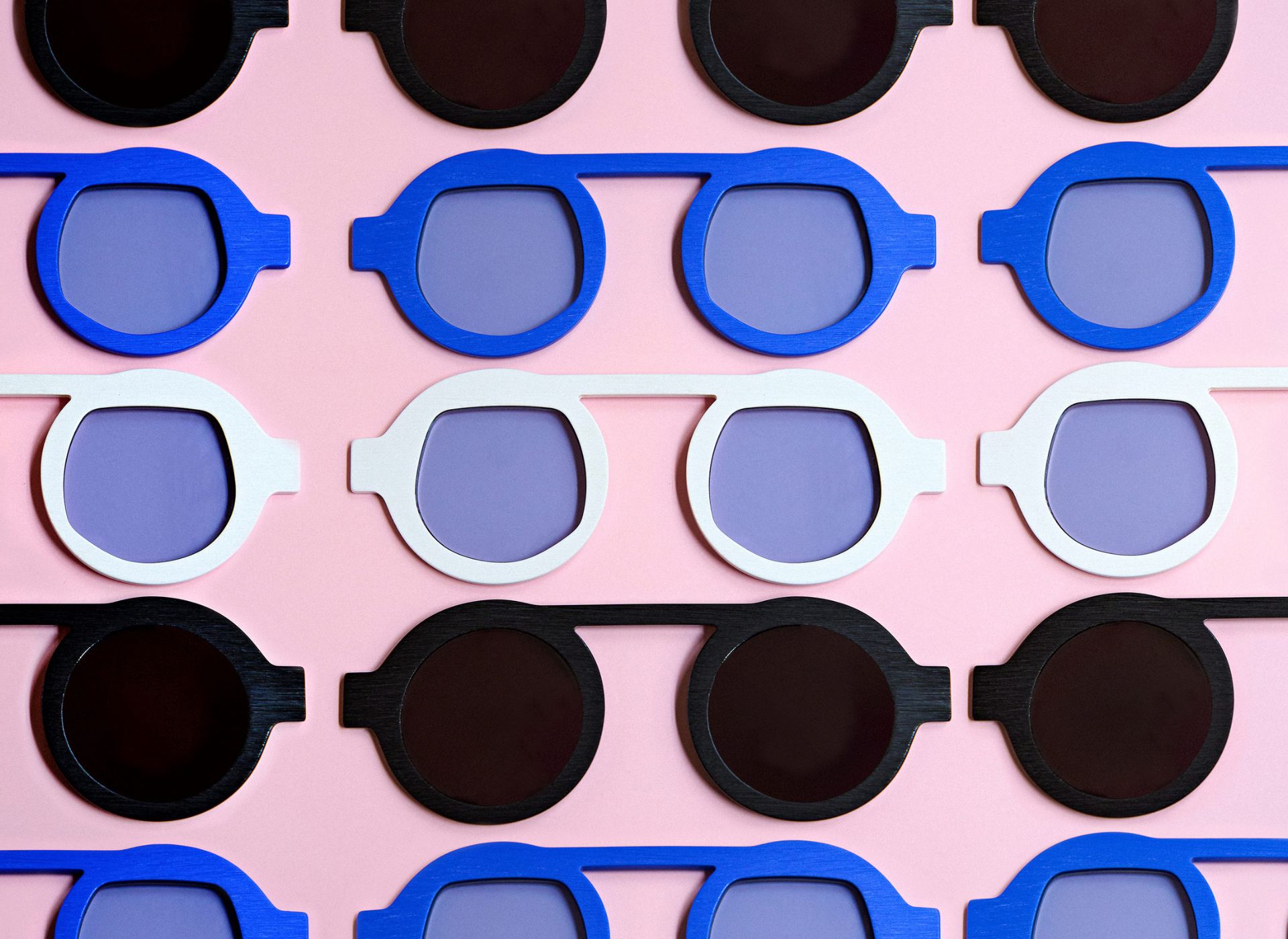 A flat lay image of various symmetrical frames against a pink backdrop