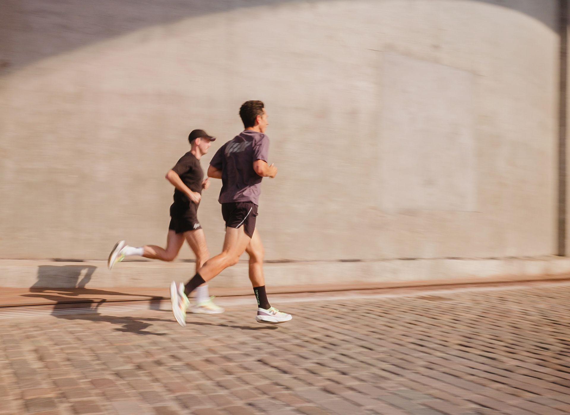Image of Jack and Peter running in front of concrete urban building