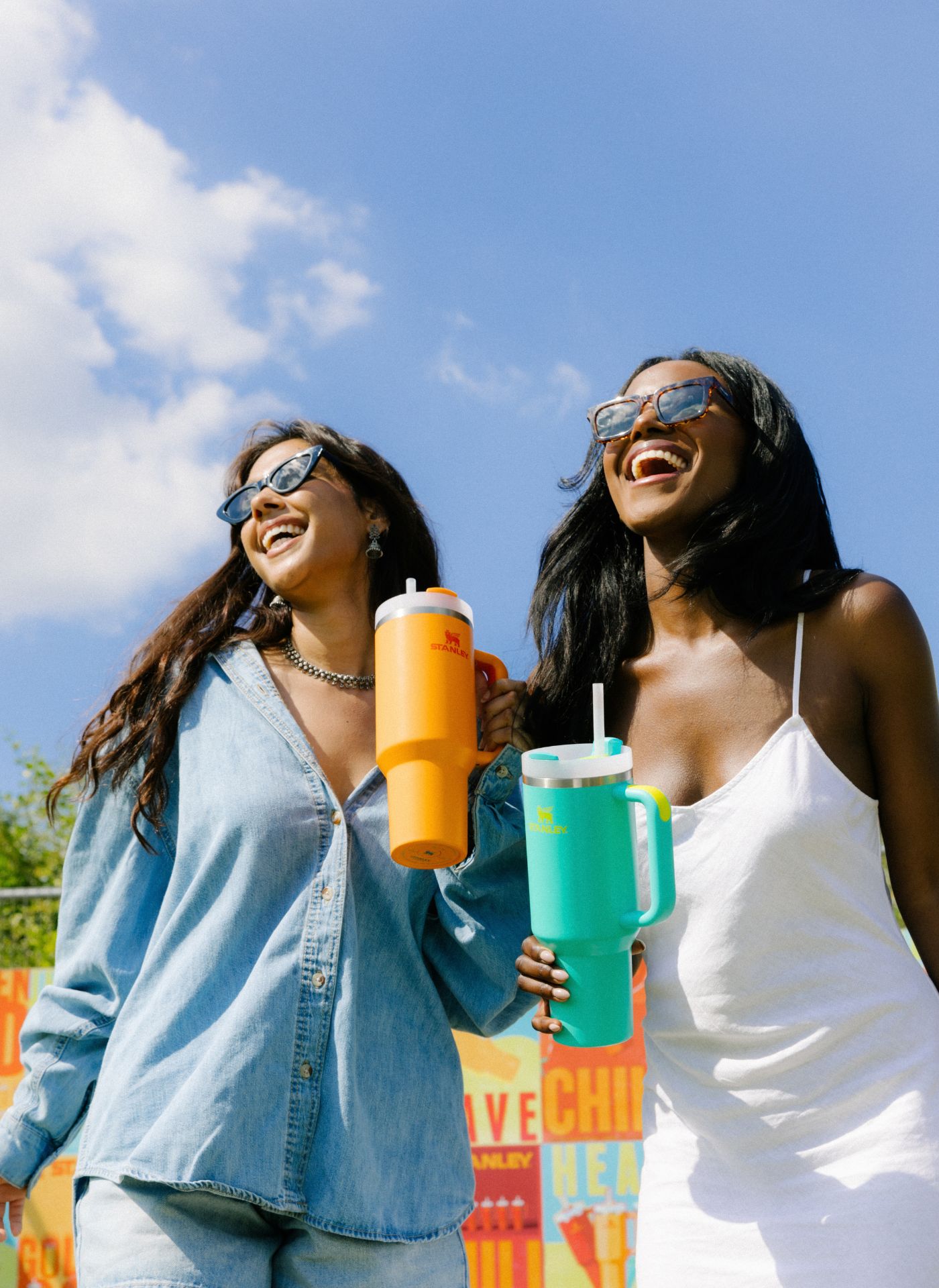 Image of two women holding Stanley Quenchers smiling and laughing in the sun