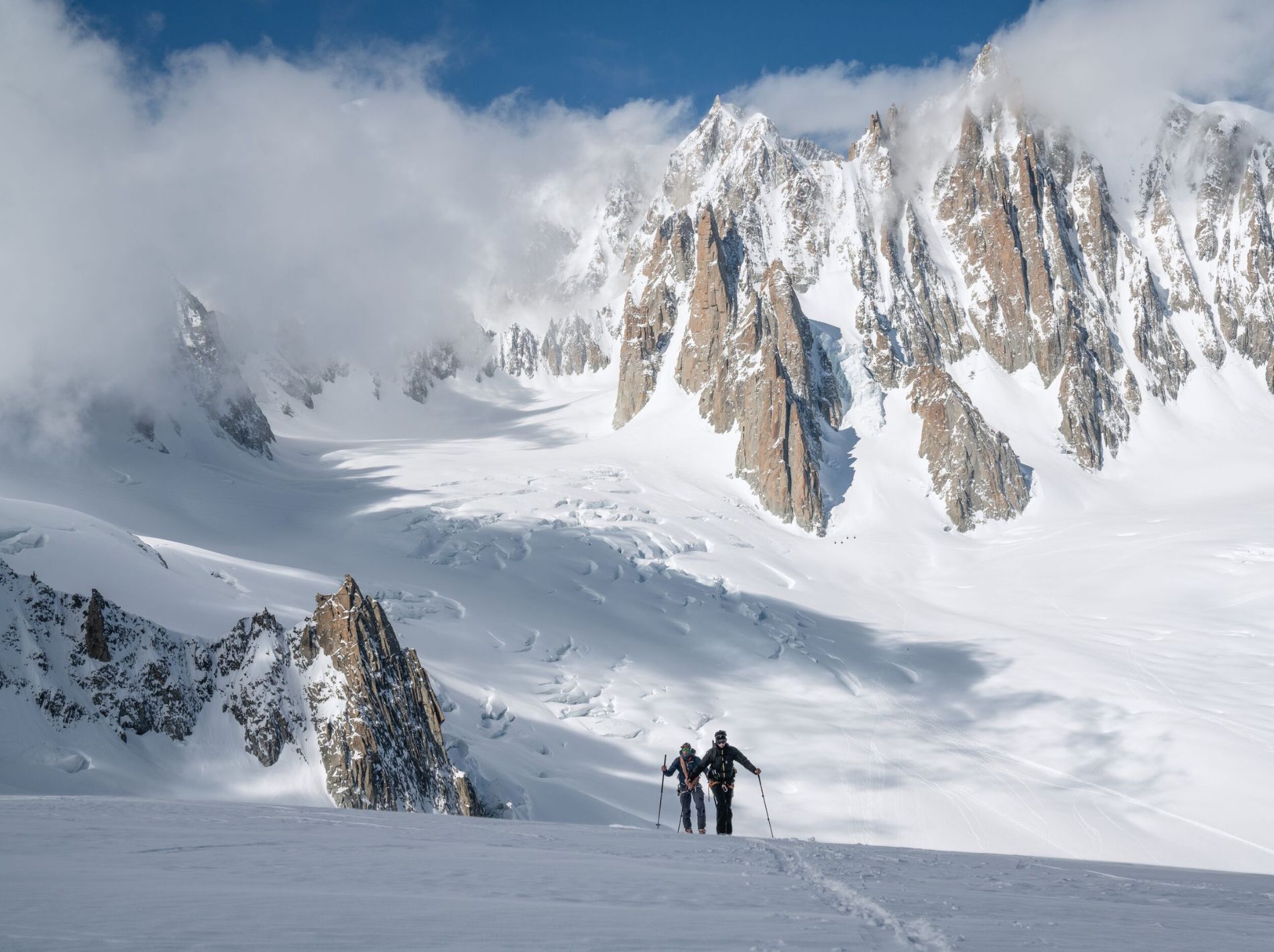 wide shot of backcountry skiers in mountains