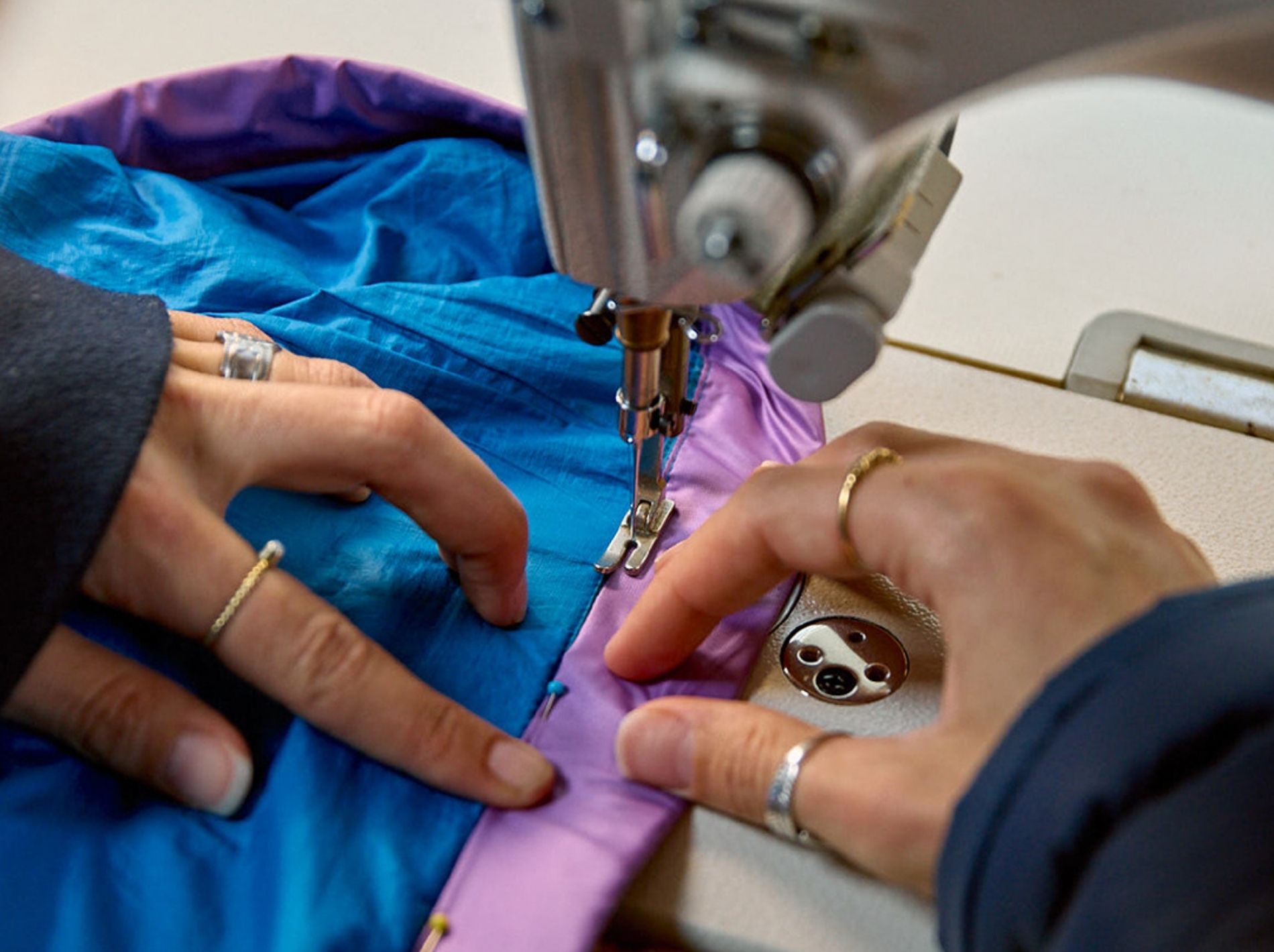 Image of hands repairing a jacket using a sewing machine