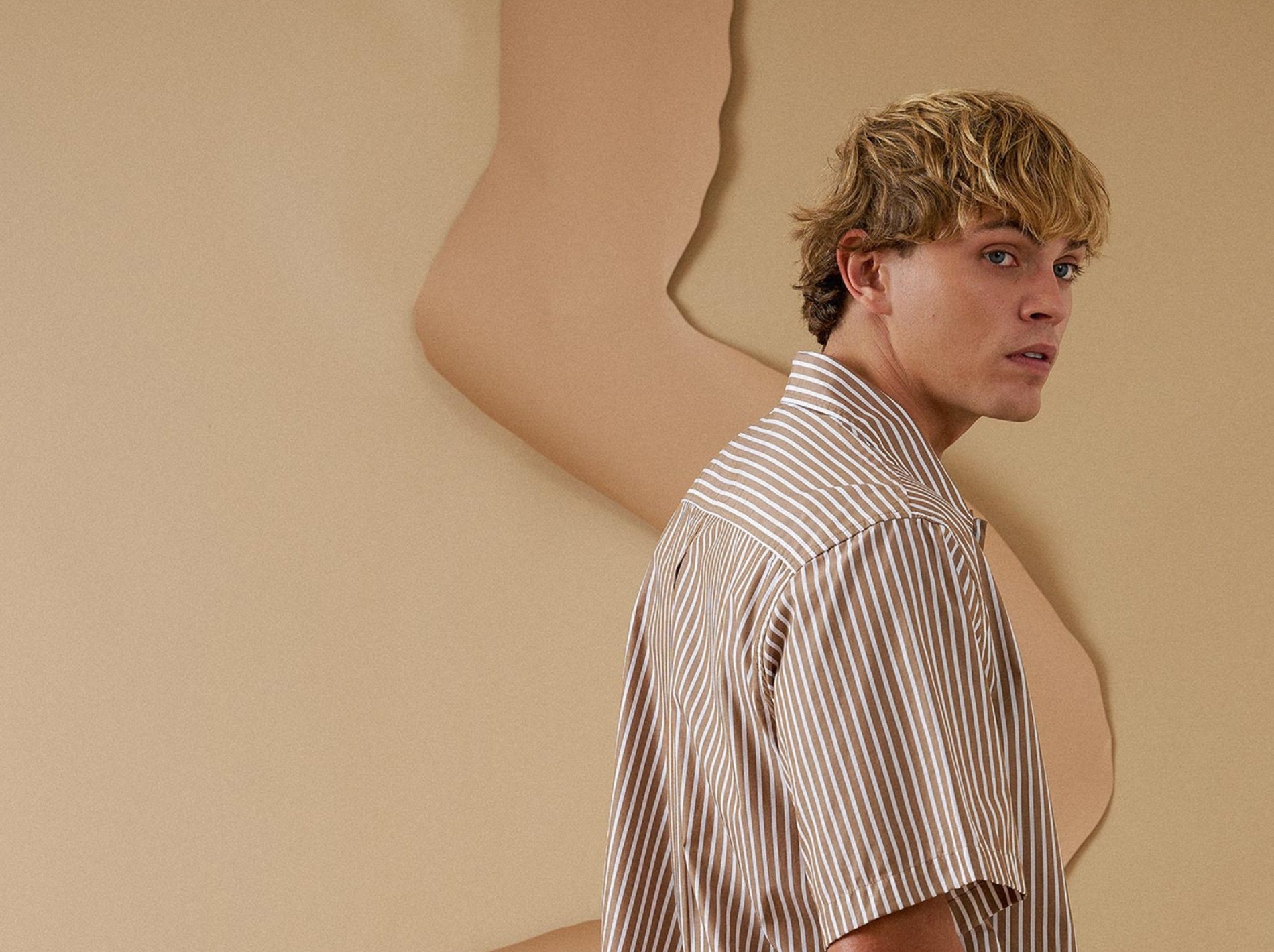 Model wearing striped shirt in Hotel Deluxe shoot